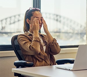 Woman at work with hands to her temples